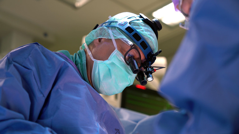 [Translate to Arabisch:] Arzt mit Operationsbrille während einer Operation in der Klinik für Kardiochirurgie im Albertinen Krankenhaus/Albertinen International in Hamburg 